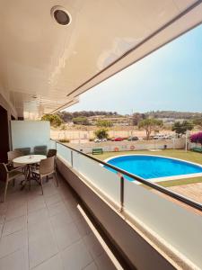a balcony with a table and a swimming pool at Relax LUX apartment on Fenals beach in Lloret de Mar