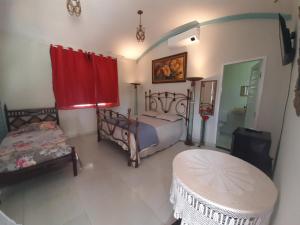 a bedroom with a bed and a table and a window at Pousada e Museu JK in Ubajara