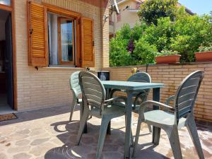 een tafel en stoelen op een patio bij casa delle margherite Ladispoli in Ladispoli