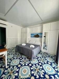 um quarto com uma cama e um piso azul e branco em TEA Luxury - Praia a Mare em Praia a Mare