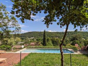 una piscina en un patio con un árbol en CASA AUGUSTA en Riez