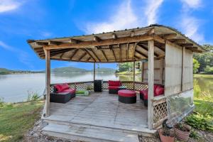 a wooden gazebo with couches and chairs on a wooden deck at Lakeside Paradise- 4BR Retreat on Neely Henry Lake home 