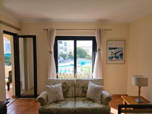 - un salon avec un canapé et une grande fenêtre dans l'établissement T1 Poente da Aldeia 336 Albufeira, à Albufeira