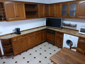 a kitchen with wooden cabinets and a washing machine at la maison du centre in Irún