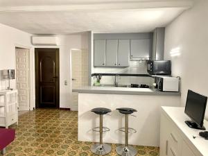 - une cuisine avec un comptoir et deux tabourets dans l'établissement Apartamento Cabañas 1, à Dénia