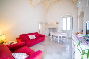 a living room with a red couch and a table at Dimora Storica La Torre Nel Borgo in Borgagne