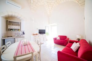 a living room with a red couch and a table at Dimora Storica La Torre Nel Borgo in Borgagne