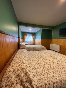 a room with three beds in a room at Hospedaje Polz in Puerto Montt