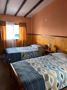 a hotel room with two beds and a window at Hospedaje Polz in Puerto Montt
