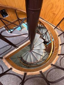 a spiral staircase with a metal railing in a room at Hospedaje Polz in Puerto Montt