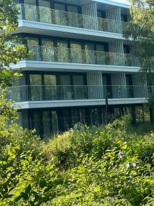 Apartament Sea & Lake z basenem Silence Mielno في ميلنو: مبنى مكتب به الكثير من النوافذ