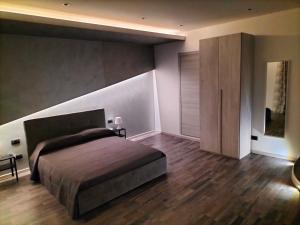 a bedroom with a large bed and a wooden floor at Santiago Rooms in Caltagirone