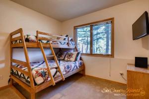 a bedroom with two bunk beds and a television at Beautiful Mountain Townhome with Private Hot Tub, Steps from Everything Breckenridge! HL305 in Breckenridge