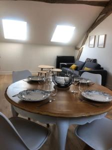 una mesa de madera con platos y copas de vino. en Le Domremy F2 au cœur d'Orléans en Orléans