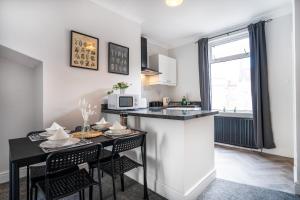 a kitchen with a table with chairs and a counter top at Central 2 Bedroom House-Parking in Bishop Auckland