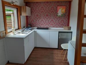 a kitchen with white cabinets and a sink and a window at Letni Spokój in Worliny