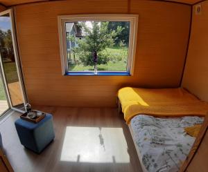 a small room with a bed and a window at Letni Spokój in Worliny +4 photos