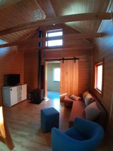 ein Wohnzimmer mit einem Sofa und einem TV in der Unterkunft Letni Spokój in Worliny