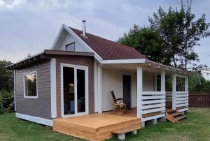 ein kleines Haus mit einer Terrasse im Hof in der Unterkunft Letni Spokój in Worliny