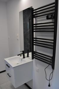 a bathroom with a white sink and a mirror at Apartament 4 Pory Roku in Darłowo