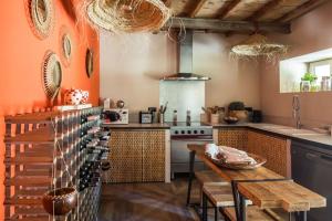 a kitchen with orange walls and a wooden table at Mas Volver Camargue in Arles