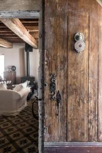 - une porte en bois dans une chambre avec un canapé dans l'établissement Campagne Volver, à Arles