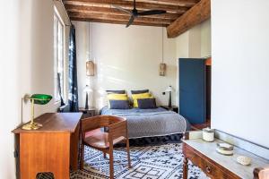 - une chambre avec un lit, une table et une chaise dans l'établissement Campagne Volver, à Arles