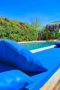 a pool with blue cushions on a table next to it at Casa Lodge (primera fila) in Vichayito
