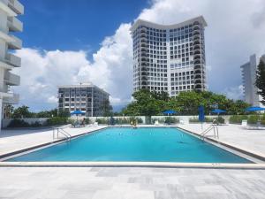 una piscina con dos edificios altos en el fondo en Entire Beach Front Condo w/ pool Amazing view 4pax, en Miami Beach
