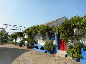 a row of blue and white houses with a red door at Lodge Monte Do Sobral in Alcáçovas