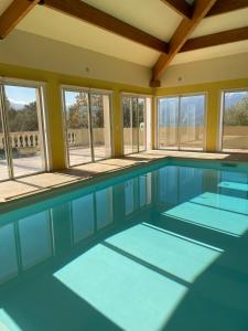 a large swimming pool with glass doors and windows at CASA DI CAJUCAN in Poggio-dʼOletta
