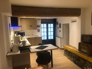 a kitchen with a table and a counter top at Demain Rando ! in Bielle