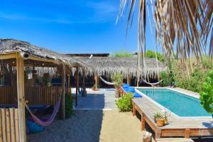a resort with a hammock and a swimming pool at Casa Lodge (primera fila) in Vichayito