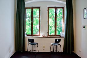 ブラチスラヴァにあるElephants Apartmentsの椅子2脚と窓2つが備わる客室です。