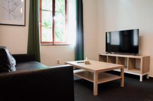 a living room with a couch and a tv and a table at Elephants Apartments in Bratislava