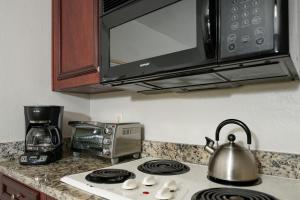 a kitchen with a stove top with a microwave at Parc Corniche Condominium Suites in Orlando