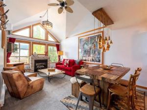 a living room with a table and a red couch at Stunning 2BR w Pool, Hot Tub Walk to everything! in Whistler