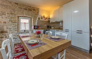 eine Küche mit einem Holztisch und weißen Schränken in der Unterkunft 2 Bedroom Cozy Home In Filipana in Filipana