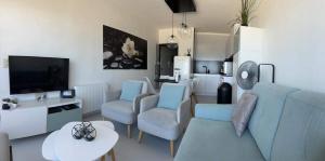 a living room with a couch and chairs and a tv at Malibu Beach 9C in Blankenberge