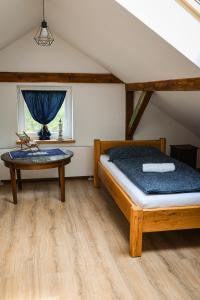 a bedroom with a bed and a table at Domy pod 12-stką in Mrągowo