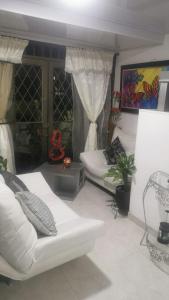 a living room with two white couches and a plant at WALOJO¡ Acogedor Apartamento, Excelente ubicación in Neiva