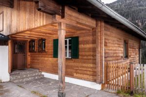 Cabaña de madera con porche y puerta en Gemütliches Ferienhaus im Defereggental, 