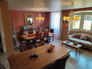 a living room with a table and a dining room at Demeure d'antan in Beblenheim