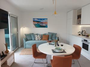 a living room with a table and a couch at JesLiving Hvar - 2 Bedroom Elegant Apartment with Sea View in Historic Center of Hvar Town in Hvar