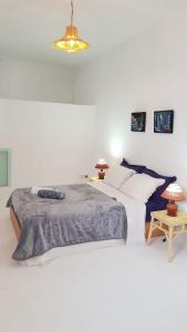 a white bedroom with a large bed and a chandelier at Alan's house Asilah in Asilah