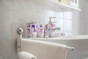 un bagno con un lavandino e un rubinetto di Budget Beds ad Alghero Altre 62 foto
