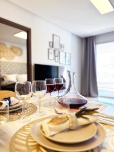a table with wine glasses and a plate of food at Maribel Apartamento Moderno in Marbella