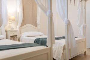 A bed or beds in a room at Trulli Ericla Luxury