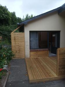 une maison avec une terrasse en bois devant elle dans l'établissement Le petit chez-vous, à La Rivière-Saint-Sauveur