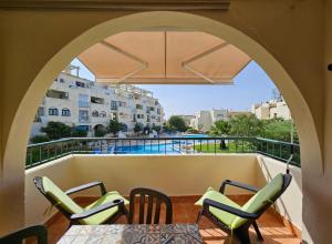 a balcony with chairs and tables and a view of a pool at T1 Poente da Aldeia 336 Albufeira in Albufeira
